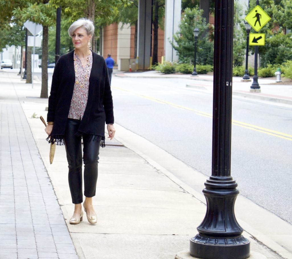 enjoying sweater weather in faux leather leggings, silk blouse and fring cardigan by style at a certain age