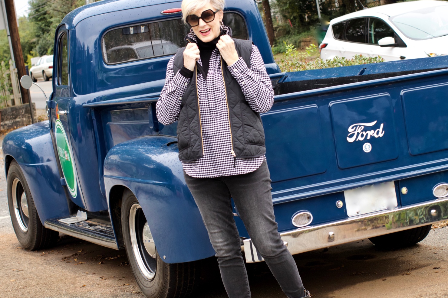 beth from style at a certain age wears high rise skinny jeans, tissue turtleneck, gingham shirt jacket, and puffer vest