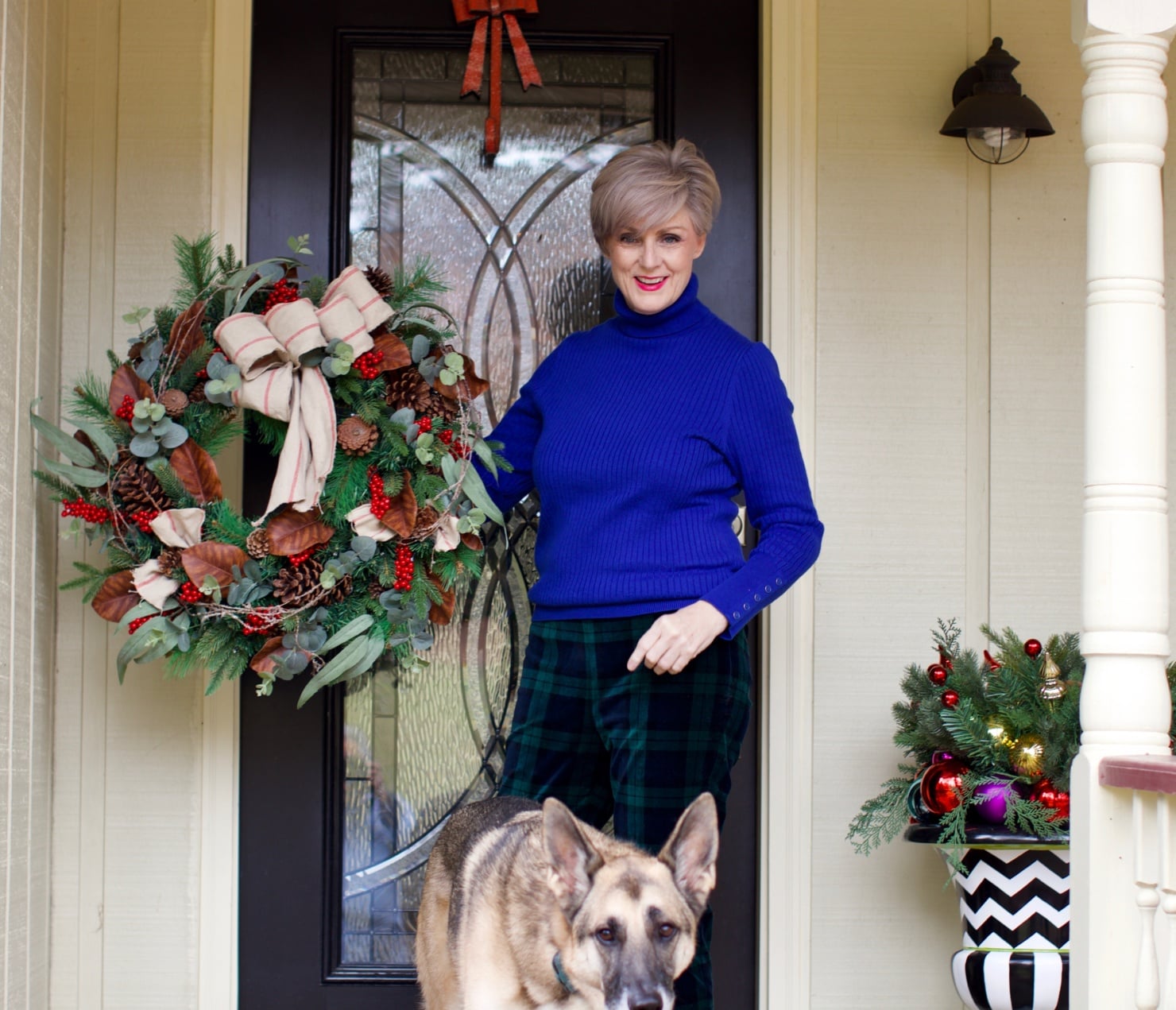 beth from Style at a Certain age wears velveteen black watch plaid pants, blue ribbed turtleneck, and loafers