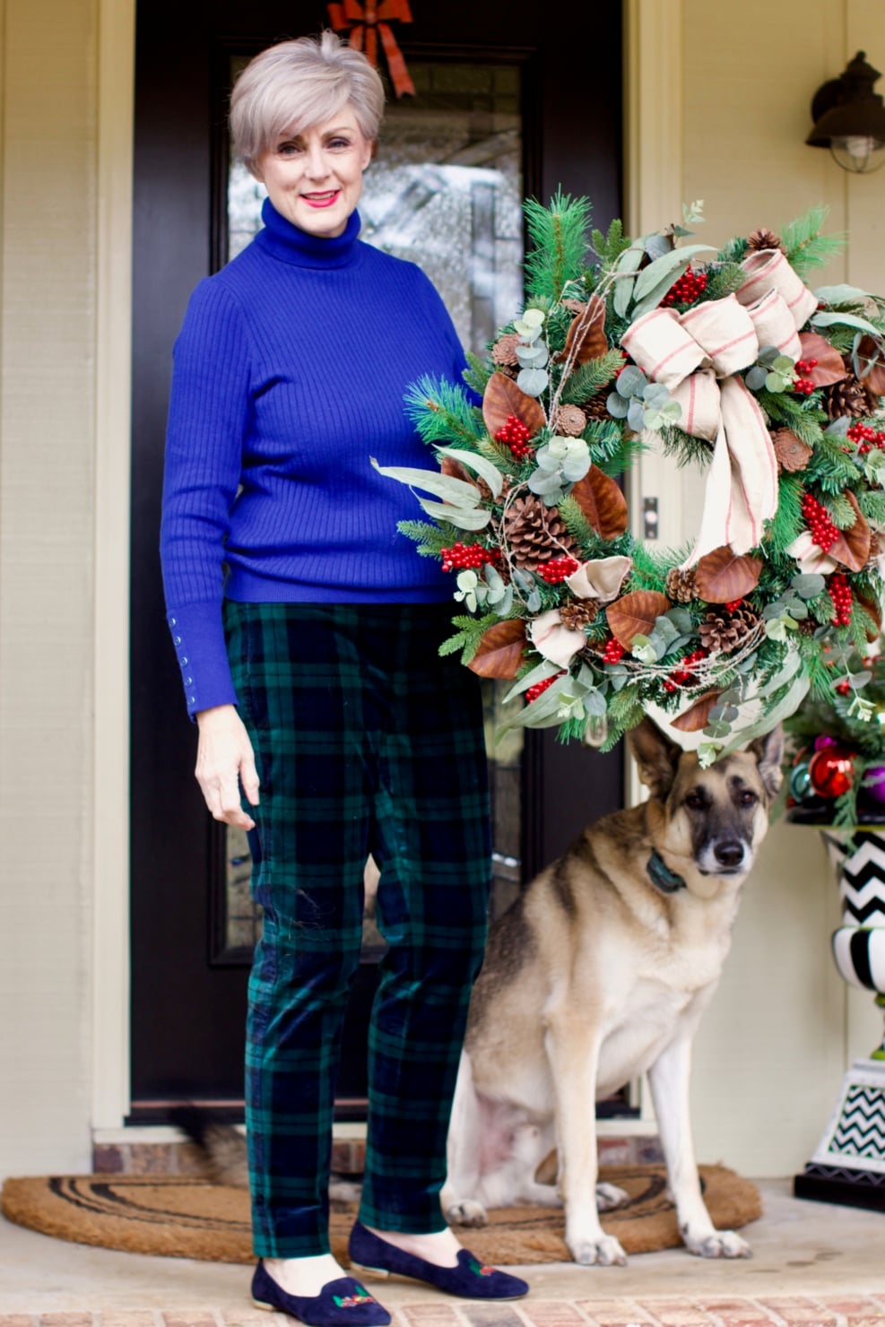 beth from Style at a Certain age wears velveteen black watch plaid pants, blue ribbed turtleneck, and loafers