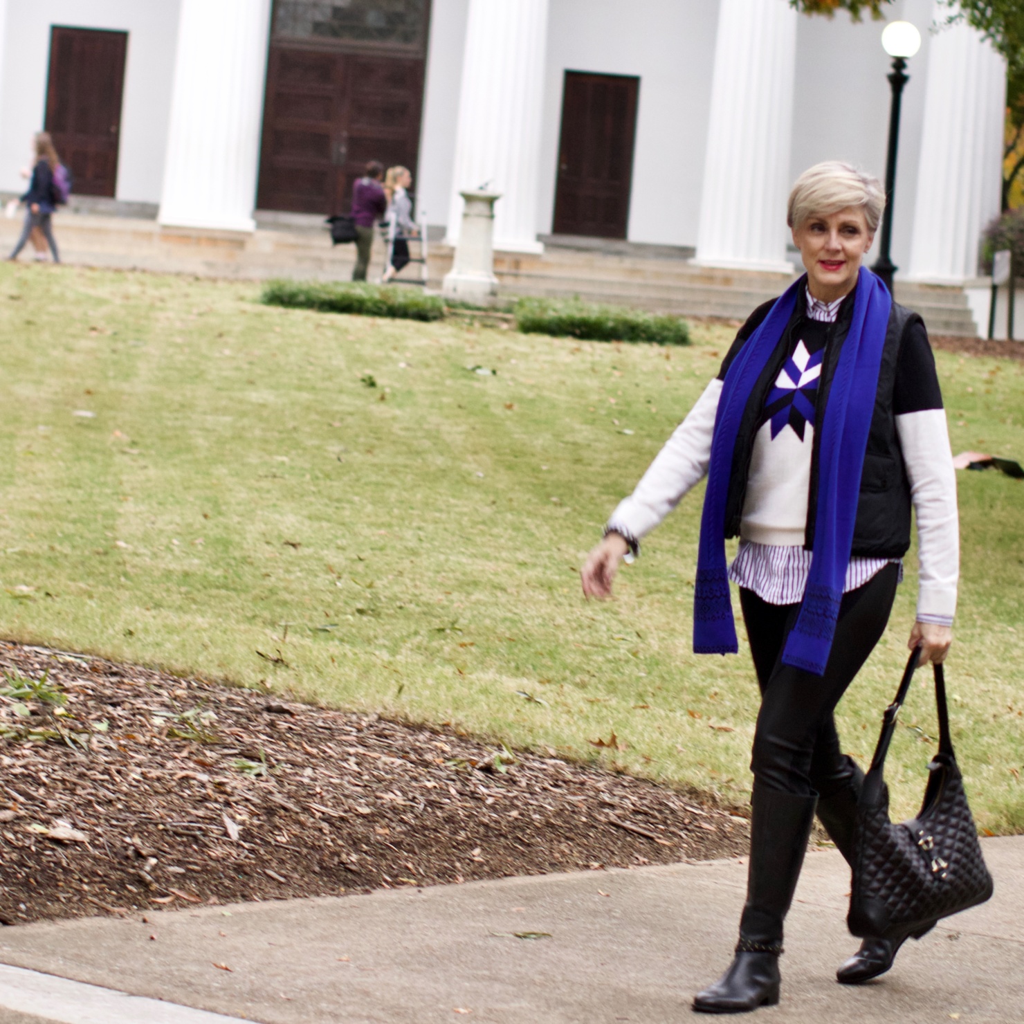 beth from Style at a Certain Age wears a snowflake intarsia sweater, DKNY ponte leggings, striped shirt, riding boots, and a cobalt blue intarsia trim scarf