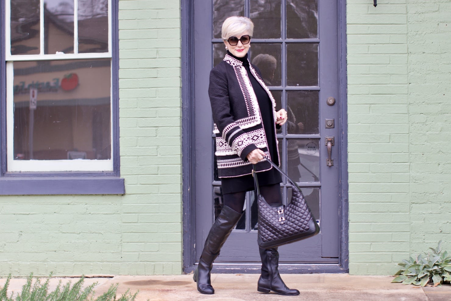 beth from style at a certain age wears a cashmere sweater dress from everlane, anthropologie embroidered jacket, black over the knee boots