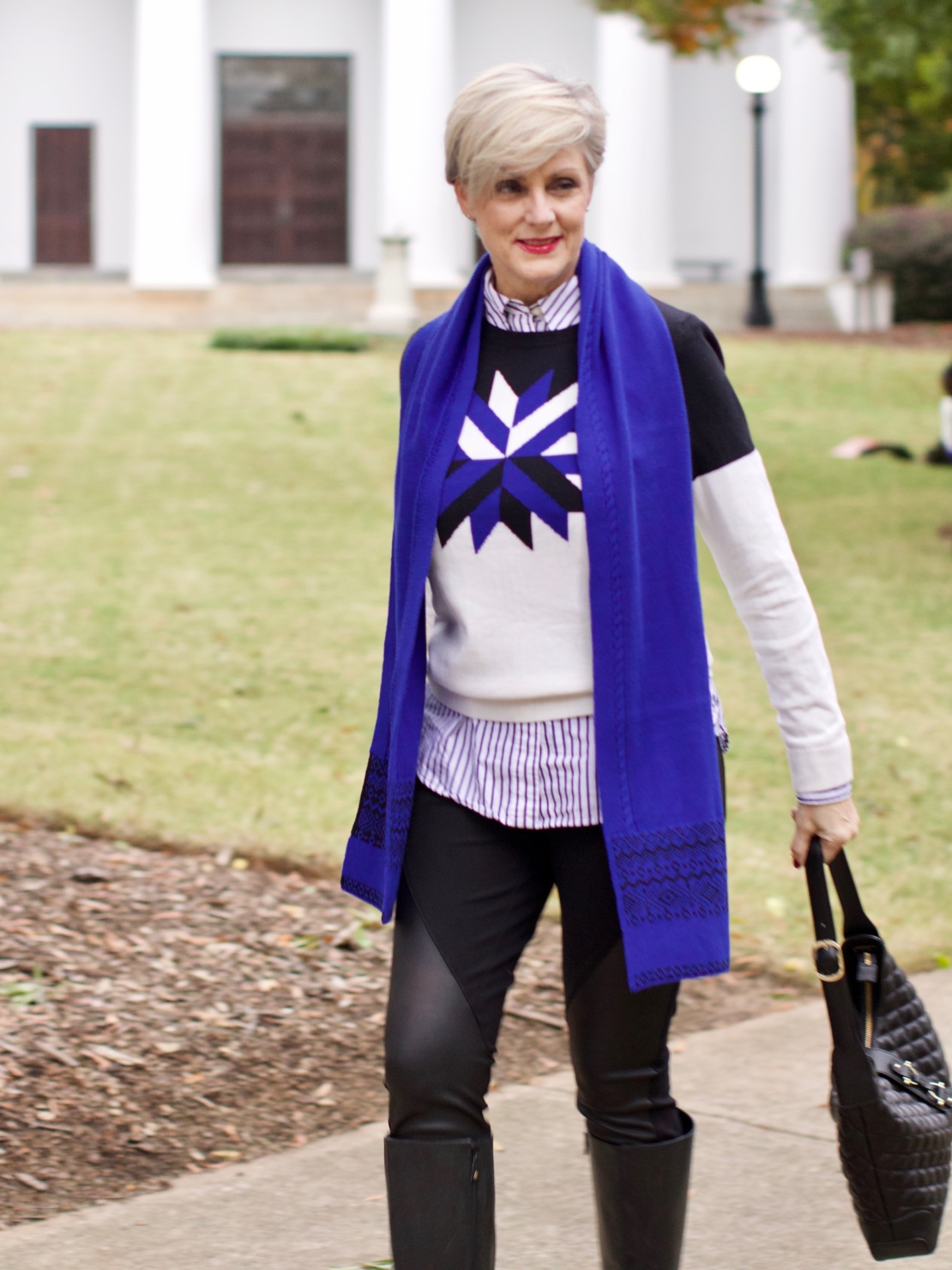 beth from Style at a Certain Age wears a snowflake intarsia sweater, DKNY ponte leggings, striped shirt, riding boots, and a cobalt blue intarsia trim scarf