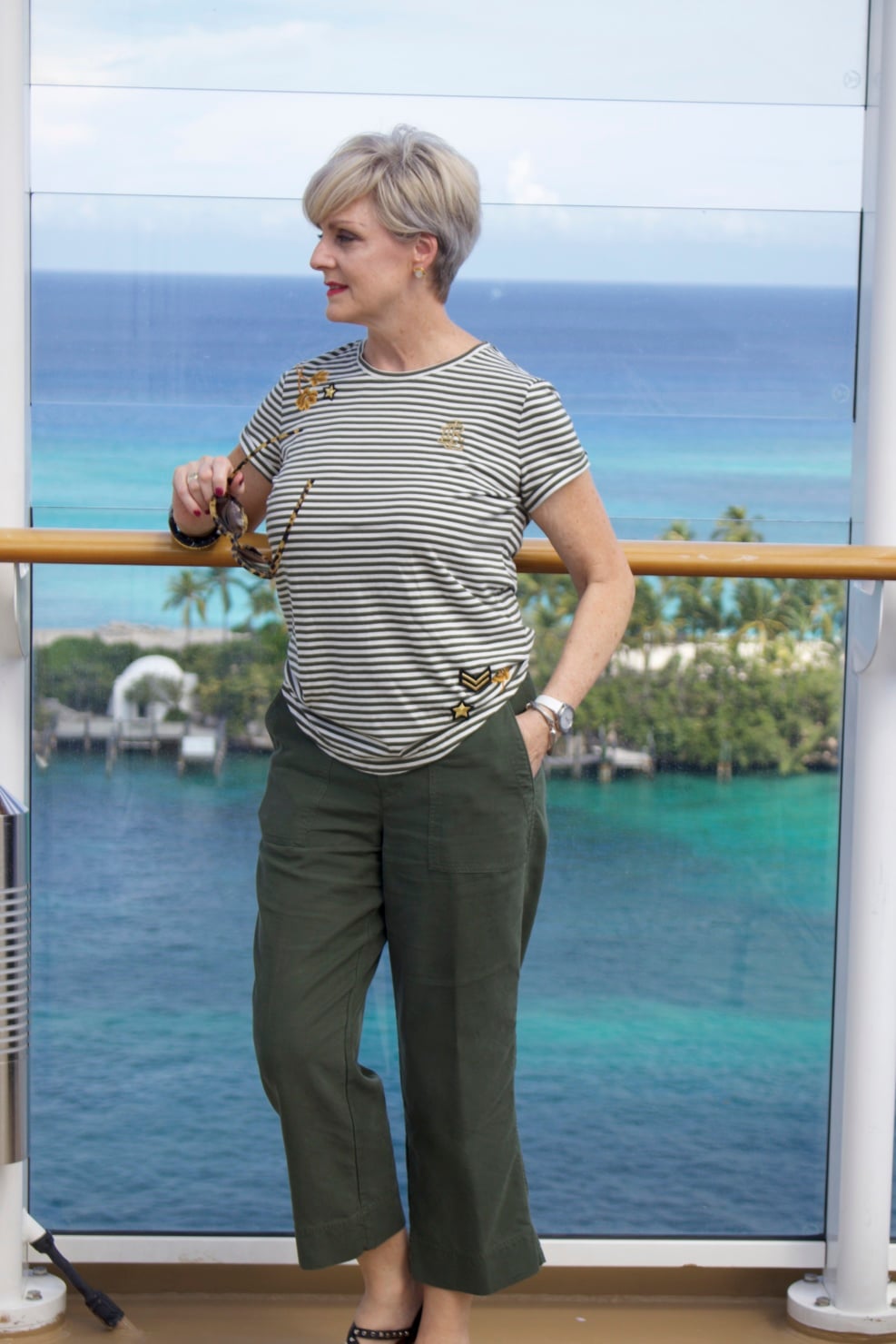 beth from Style at a Certain Age wears a Ralph Lauren military jacket, striped tee, and green cropped pants