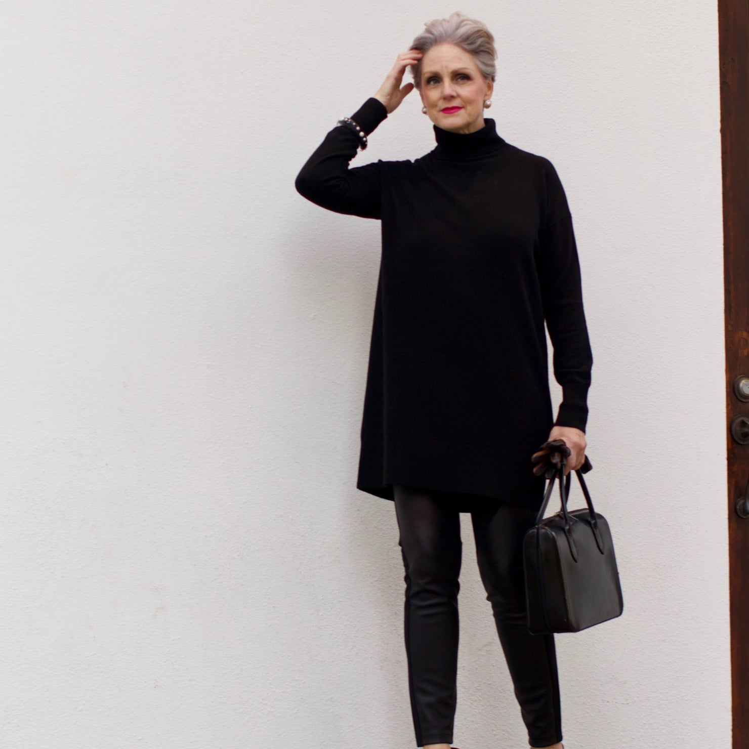 beth from Style at a Certain Age wears a black cashmere Turtleneck dress, faux leather leggings and suede pumps.