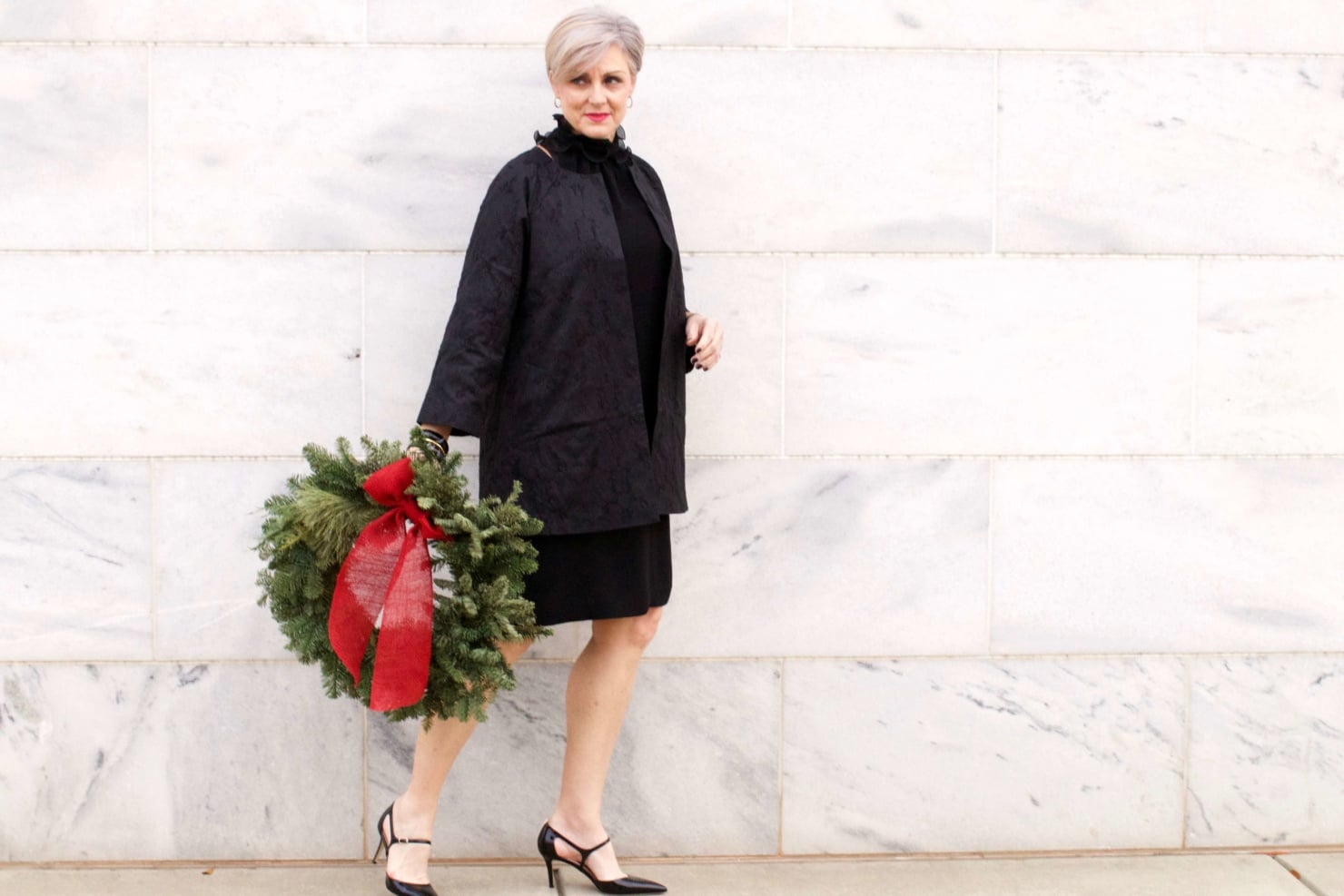 beth from Style at a Certain Age wears a Eileen Fisher shimmer jacquard 3/4 sleeve jacket and ruffled black dress