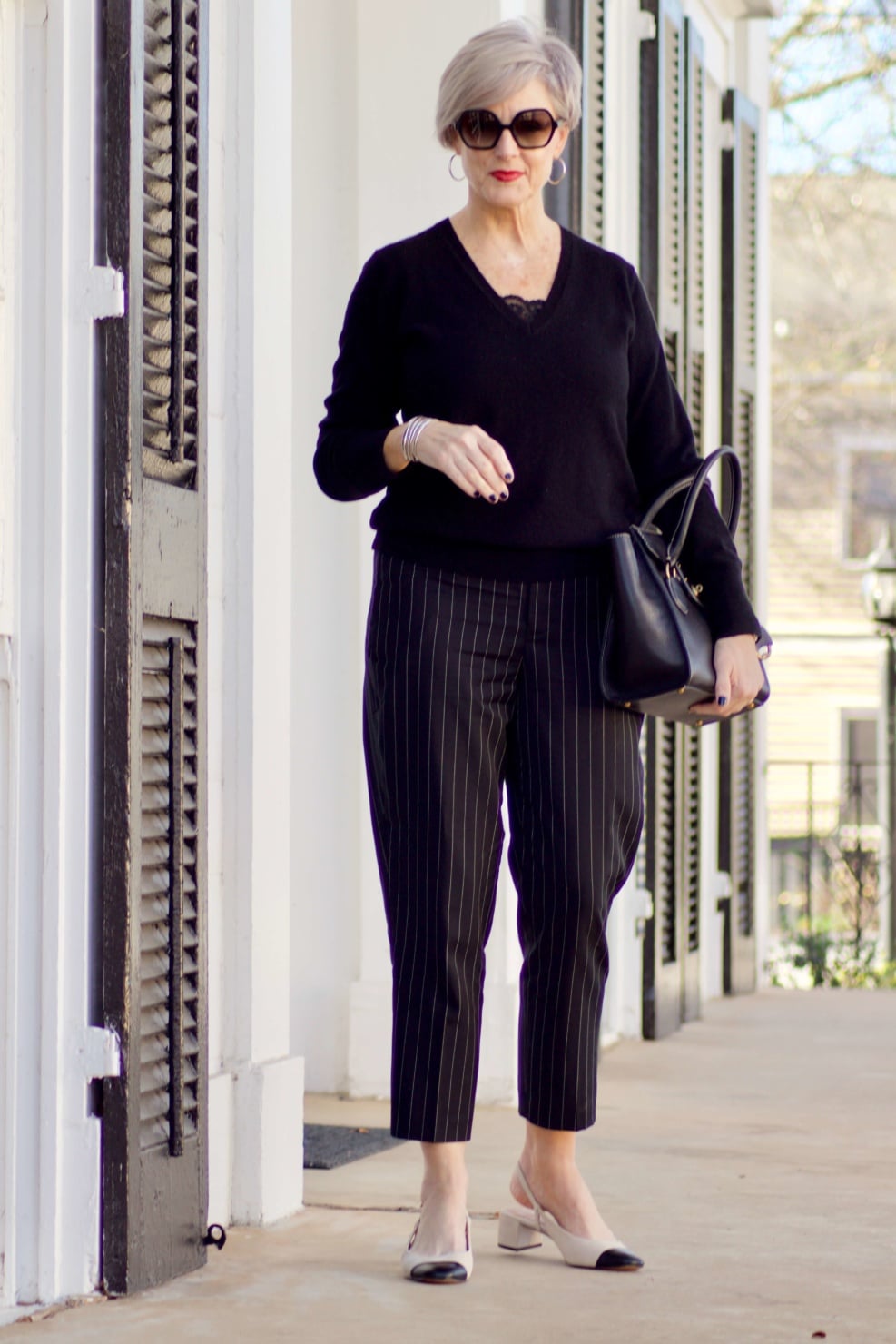 beth from Style at a Certain Age wears Ralph Lauren pinstripe pants, Everlane cashmere sweater, black leather moto jacket, and cap toe slingbacks