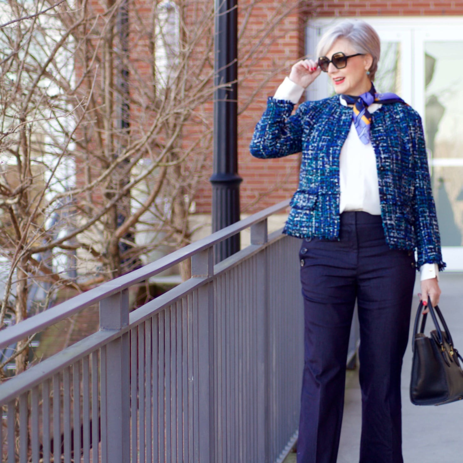 beth from Style at a Certain Age wears an Ann Taylor blue tweed jacket, faux denim sailor pants, v neck button sleeve blouse, silk ribbon chain scarf, and pointy toe booties