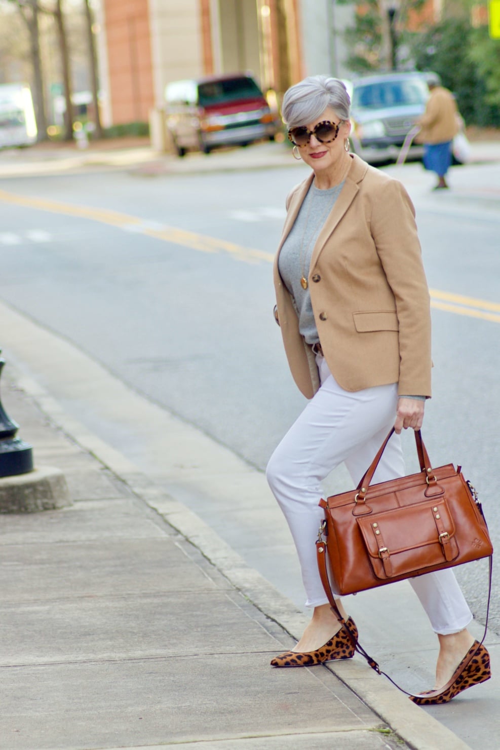 beth from Style at a Certain Age wears a camel blazer, grey cashmere crewneck, white denim, and leopard shoes