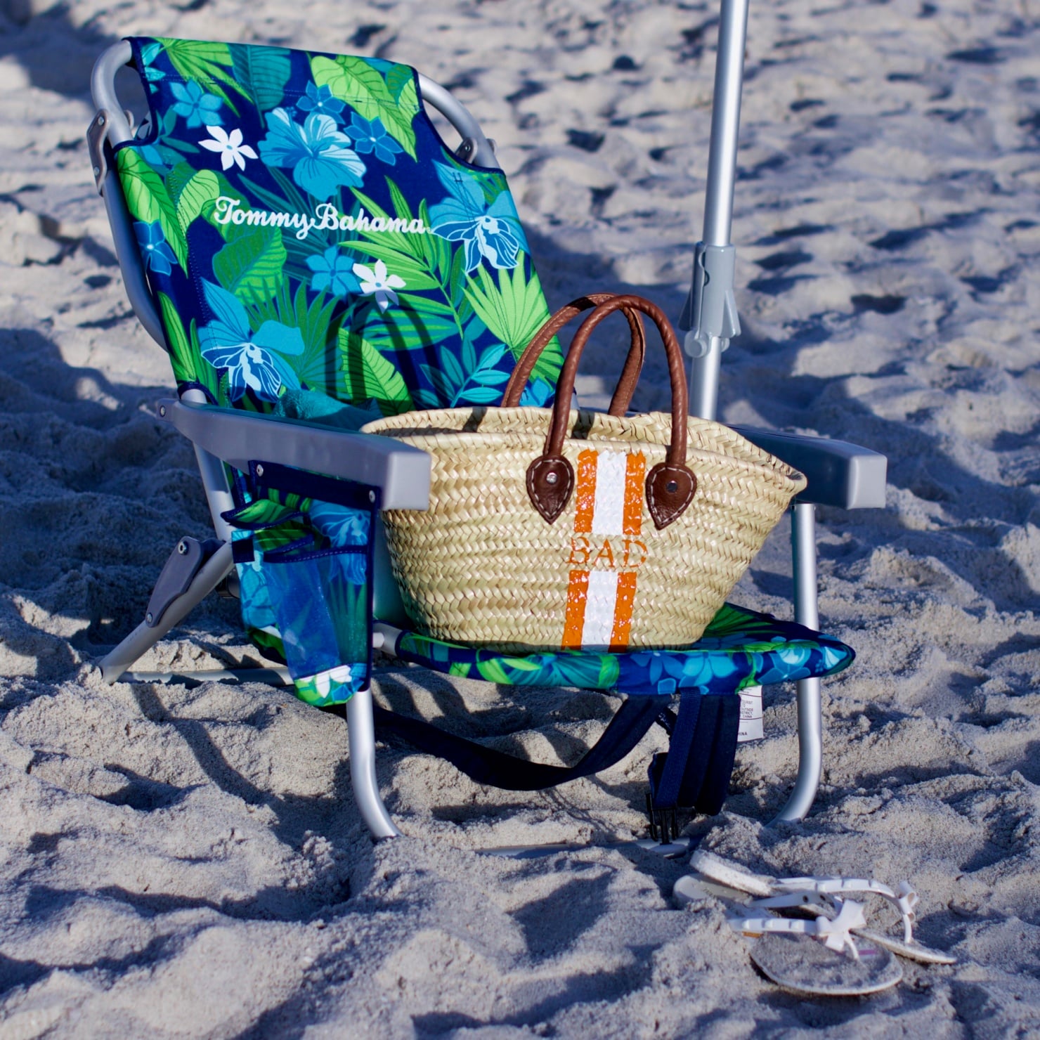 beth from Style at a Certain Age wears beach essentials, Ralph Lauren striped one-piece swimsuit, Tory Burch cover-up, jelly flip-flops, panama hat, and straw tote
