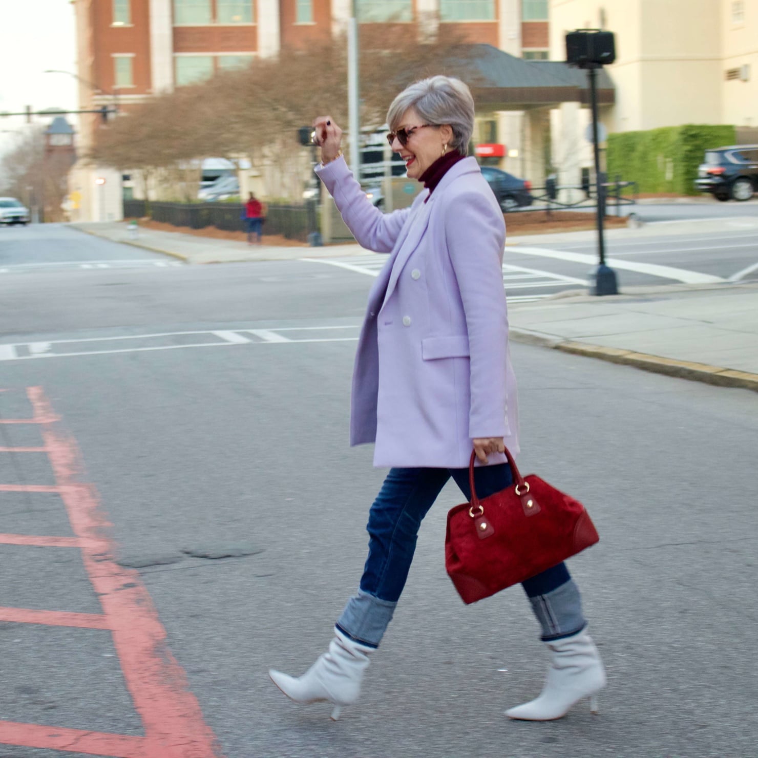 beth from Style at a Certain Age wears a striped turtleneck, lilac blazer, cuffed denim, grey suede boots