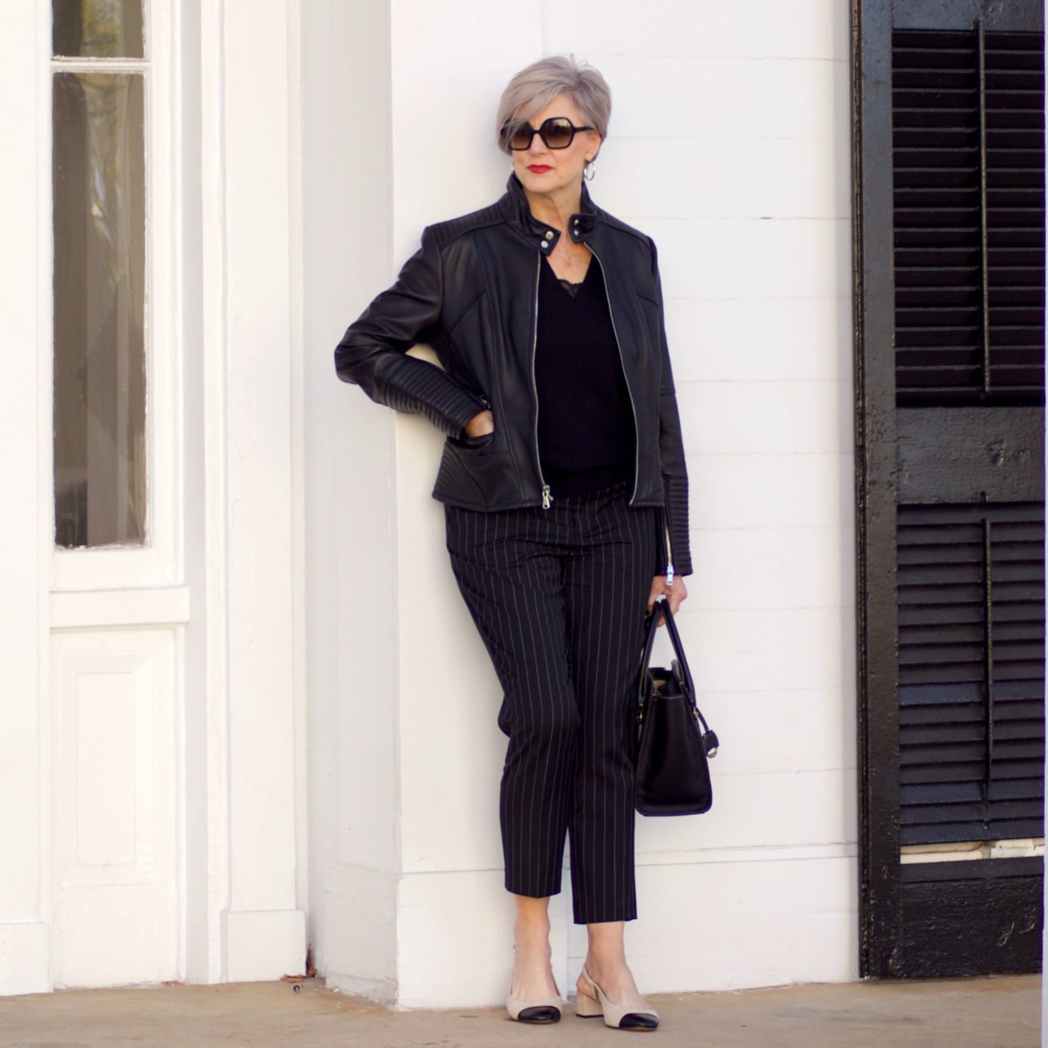 beth from Style at a Certain Age wears Ralph Lauren pinstripe pants, Everlane cashmere sweater, black leather moto jacket, and cap toe slingbacks