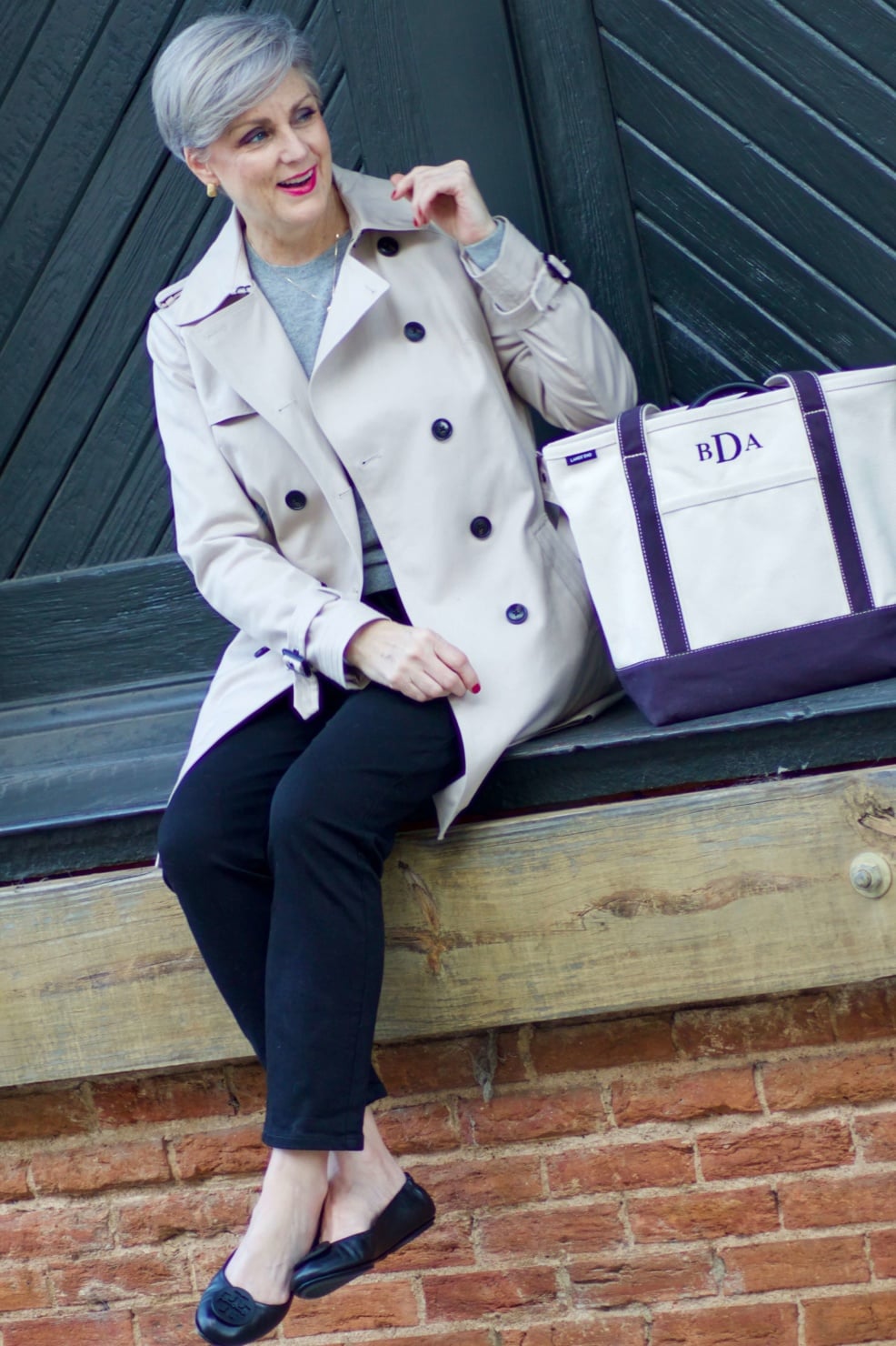 beth from Style at a Certain Age wears an Everlane grey cashmere crewneck, high rise black cigarette jean, Tory Burch black ballet flats and a double-breasted trench coat