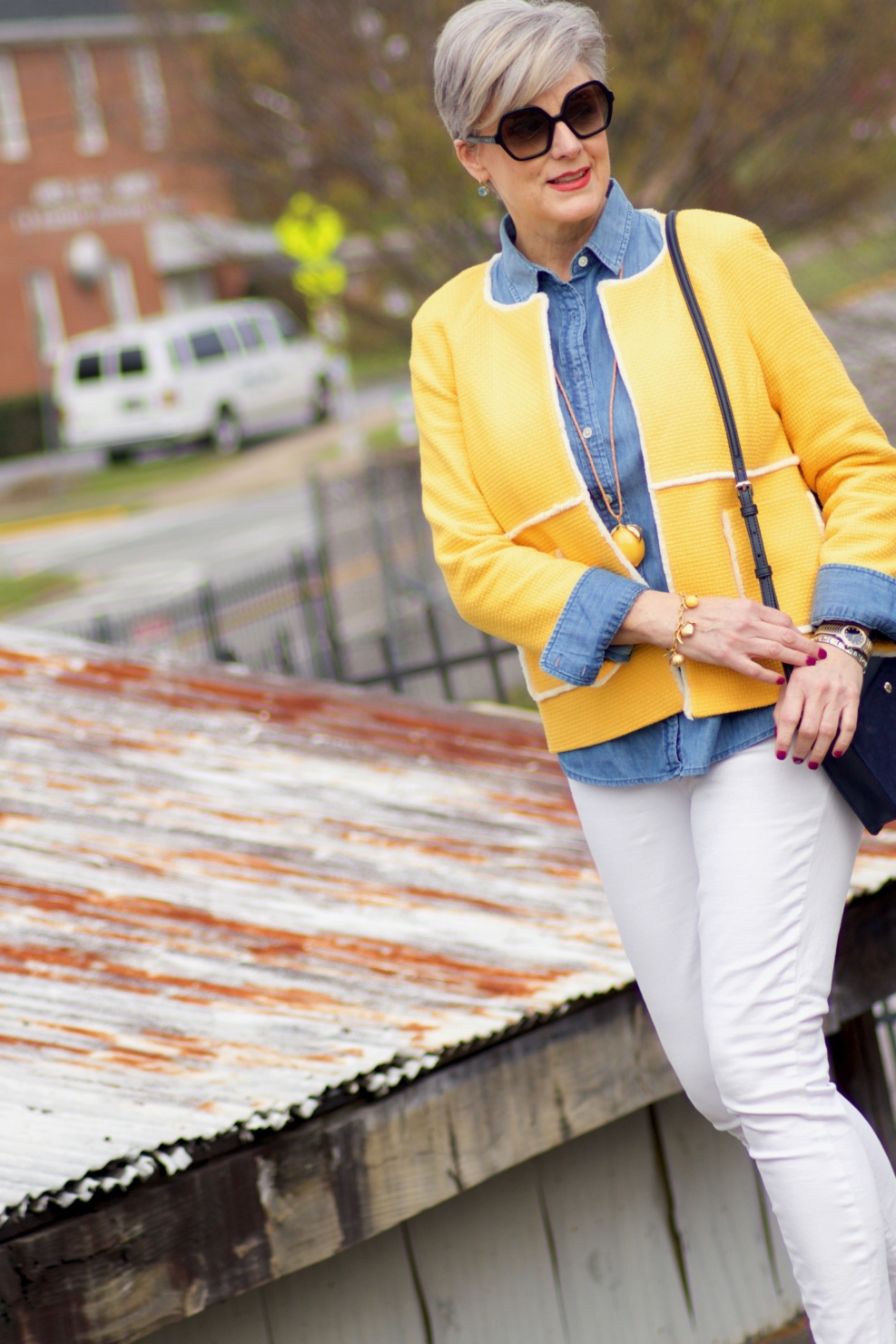 beth from Style at a Certain Age wears a Boden yellow blazer, chambray shirt, white denim and striped shoes
