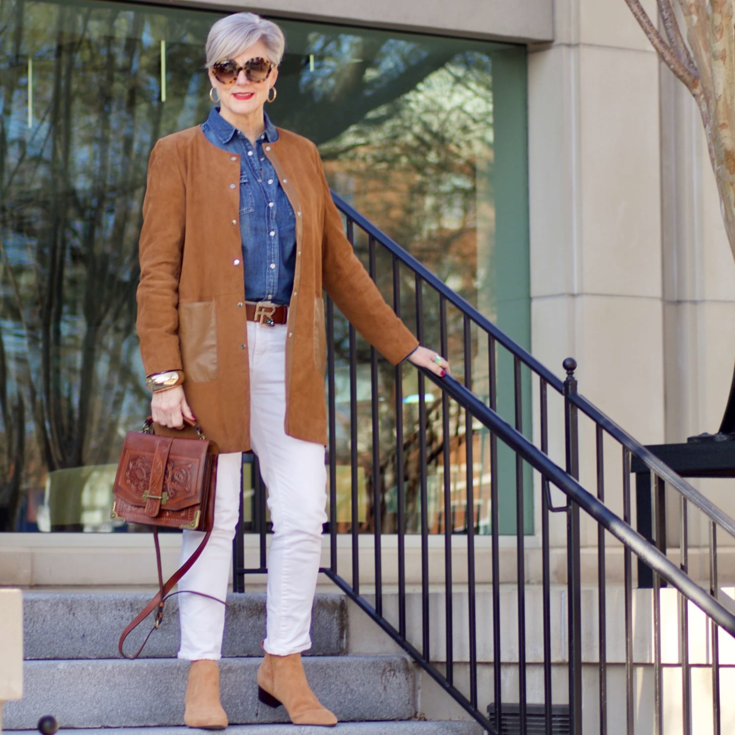 beth from Style at a Certain Age wears white denim, chambray shirt, suede jacket and booties