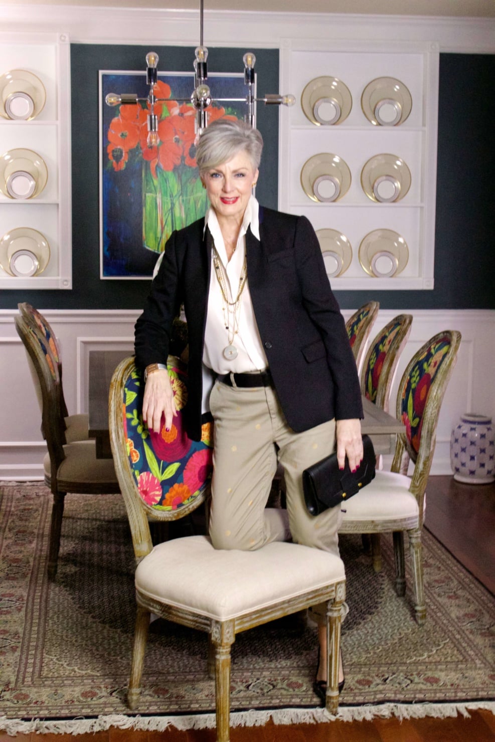 beth from Style at a Certain Age wears J.Crew chinos, black blazer, ivory silk blouse, black pumps and black clutch handbag