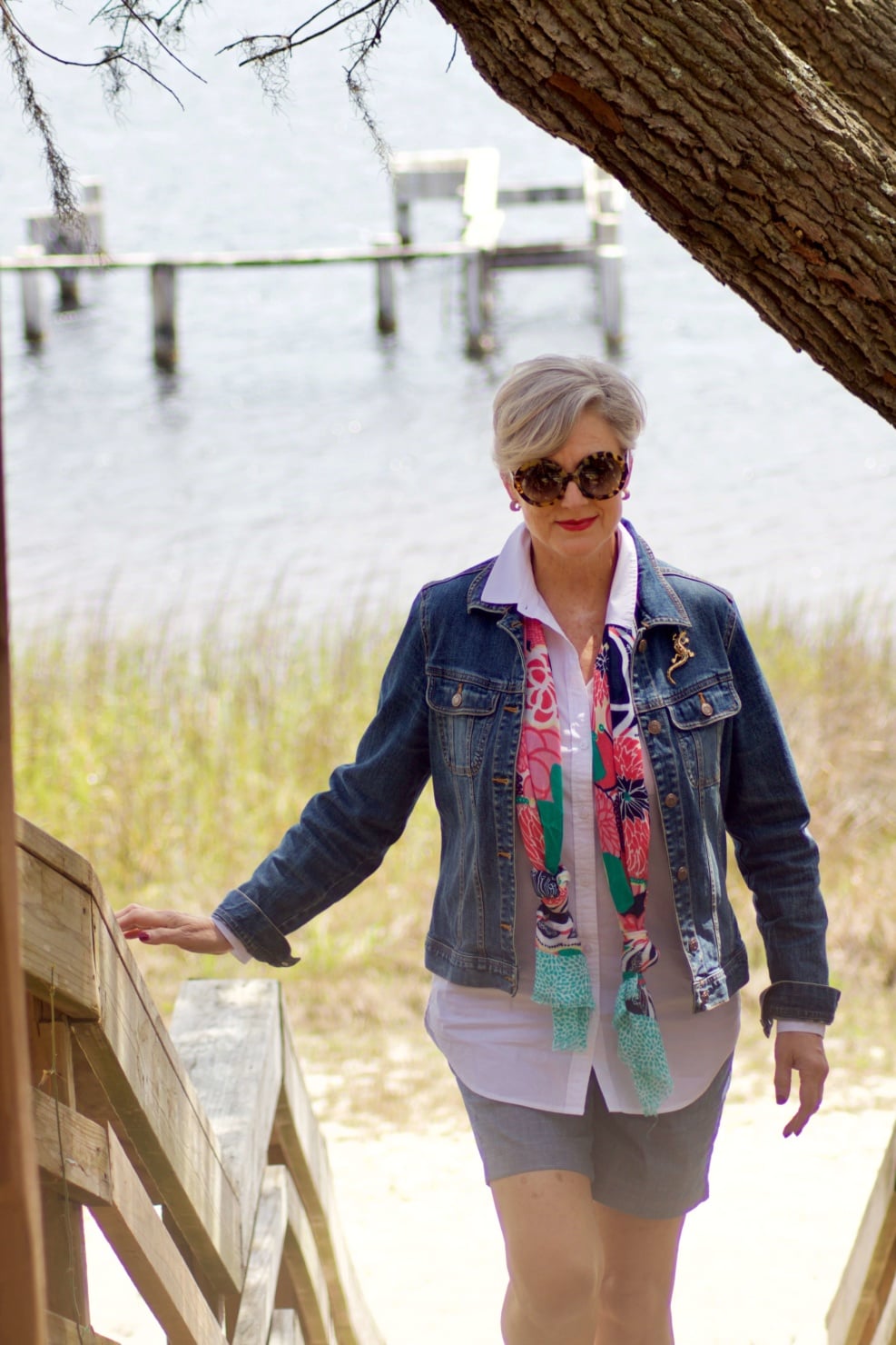 beth from Style at a Certain Age wears a white shirt, chambray shorts, jean jacket and scarf at Panama City Beach
