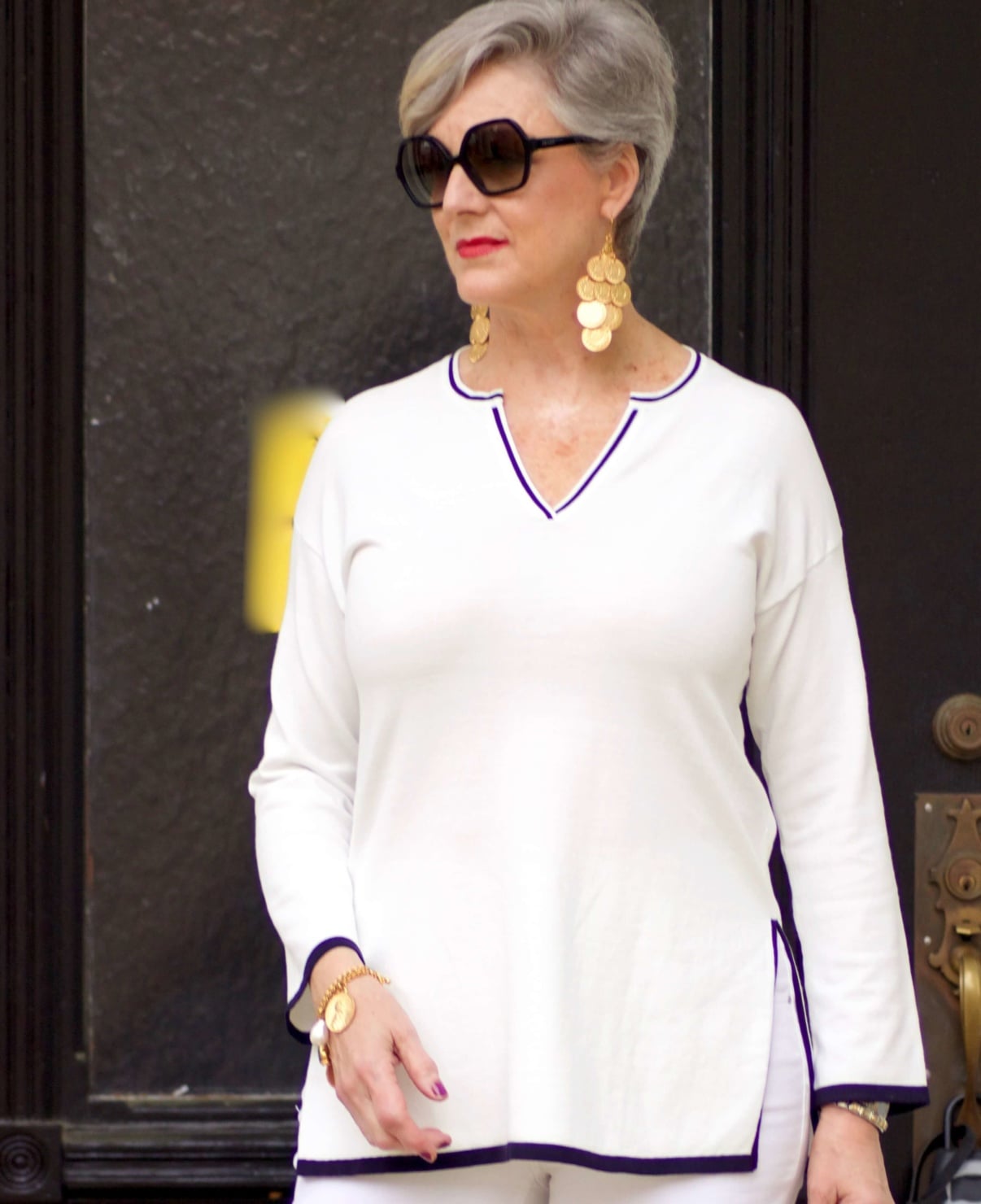 beth from Style at a Certain Age wears gold coin chandelier earrings, gold charm bracelet