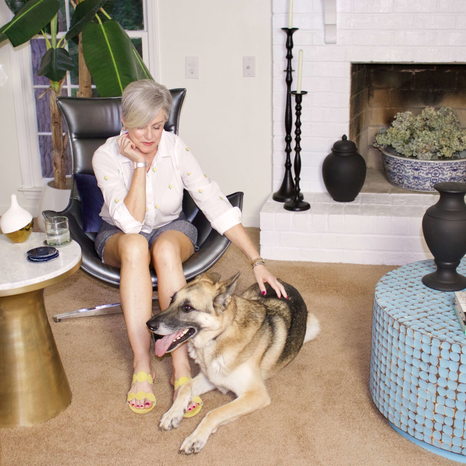 beth from Style at a Certain Age wears scalloped shorts, lemon embroidered button up, and yellow sandals