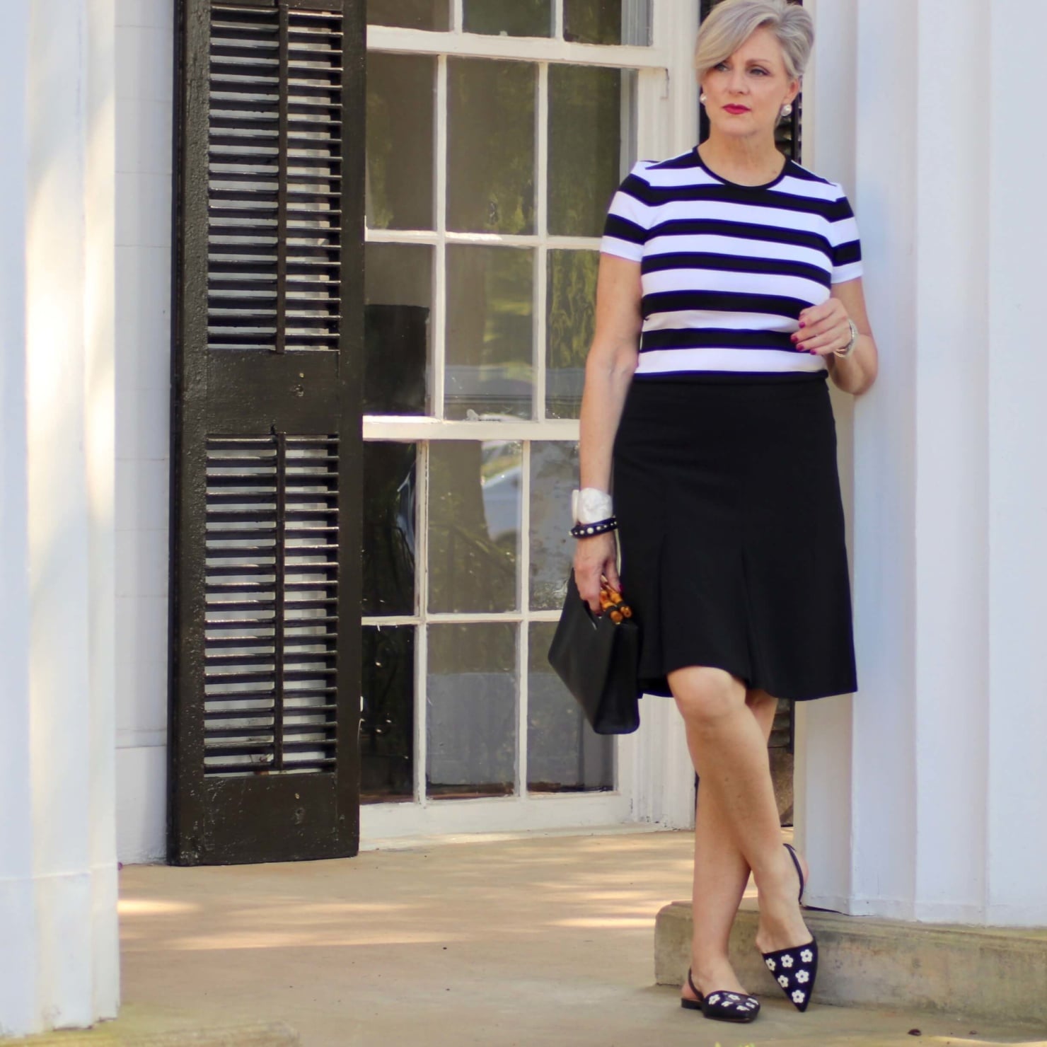 beth from Style at a Certain Age wears a black and white tee, black a-line skirt, pointy toed flats and black handbag