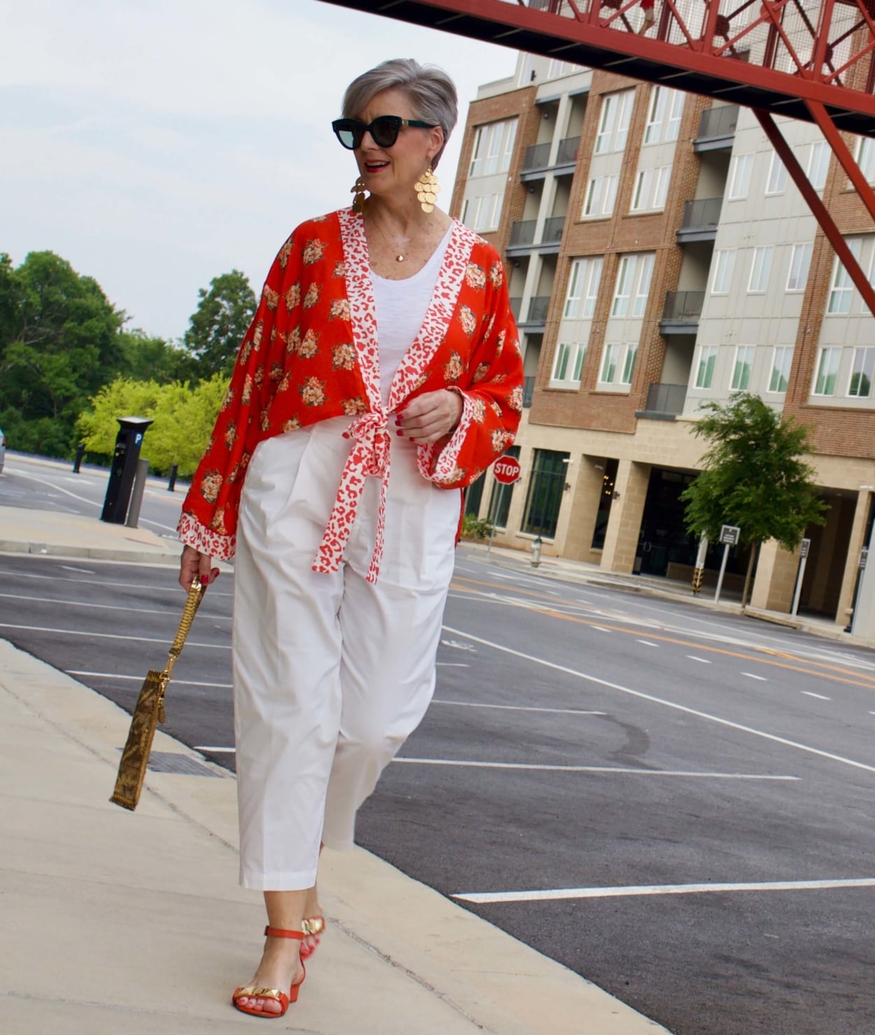 beth from Style at a Certain Age wears a kimono, white cropped chinos, white tee and orange sandals