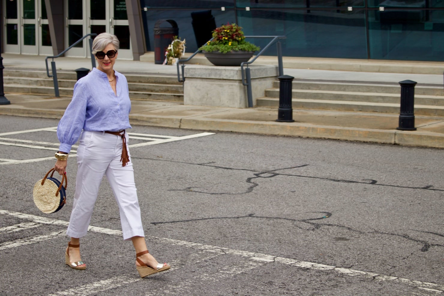 cropped white denim, striped linen shirt, cornhusk handbag, and wedge sandals