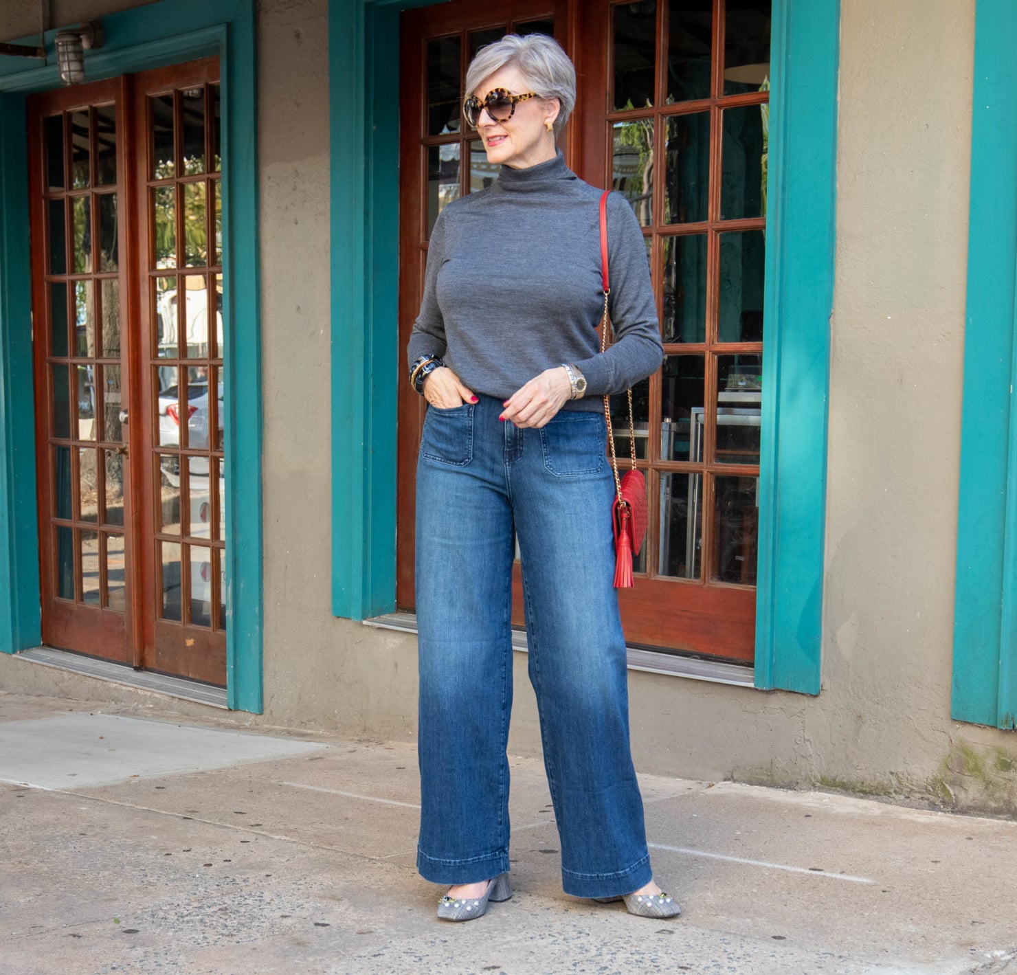 wide leg jeans, gray turtleneck, red handbag