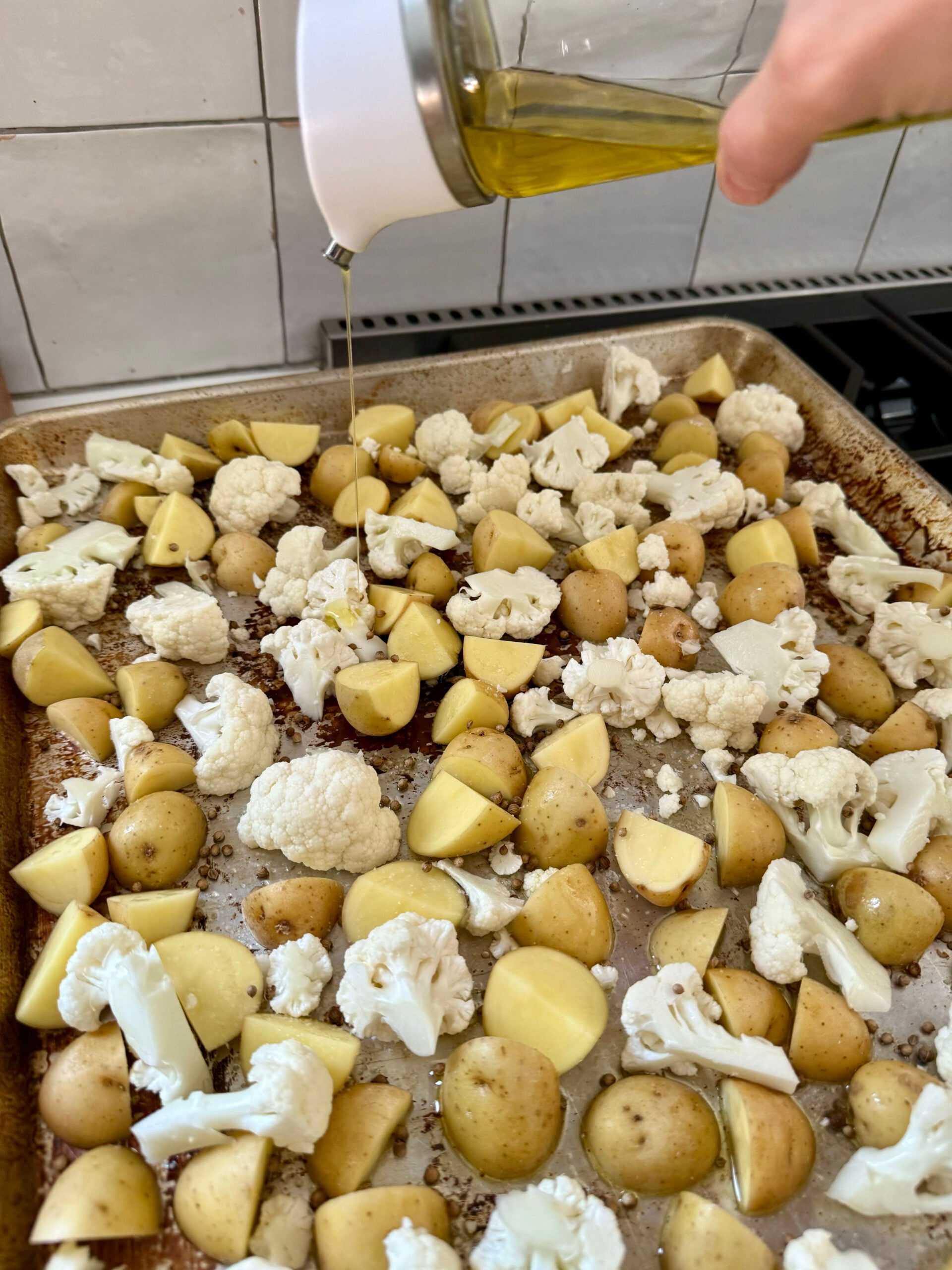 drizzle olive oil on potatoes and cauliflower