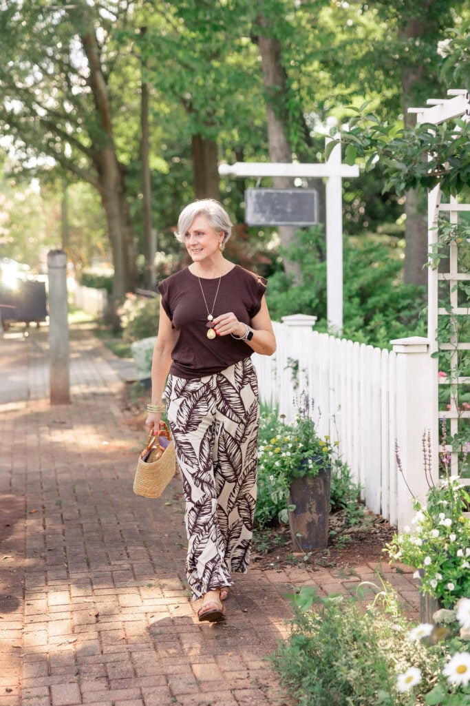 Woman in rib-trimmed tee and silky wide-leg pants, styled with sandals for a breezy, garden-inspired summer look.