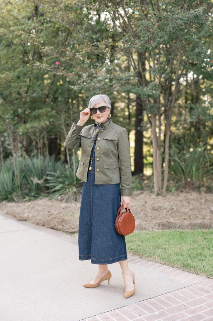 Beth Djalali wearing a fitted green utility jacket and denim dress.