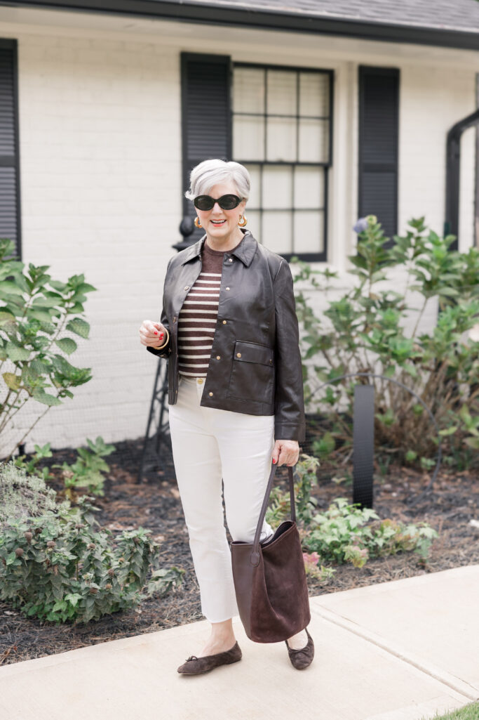 Faux-leather moto jacket styled by Beth Djalali with ivory jeans and striped sweater.