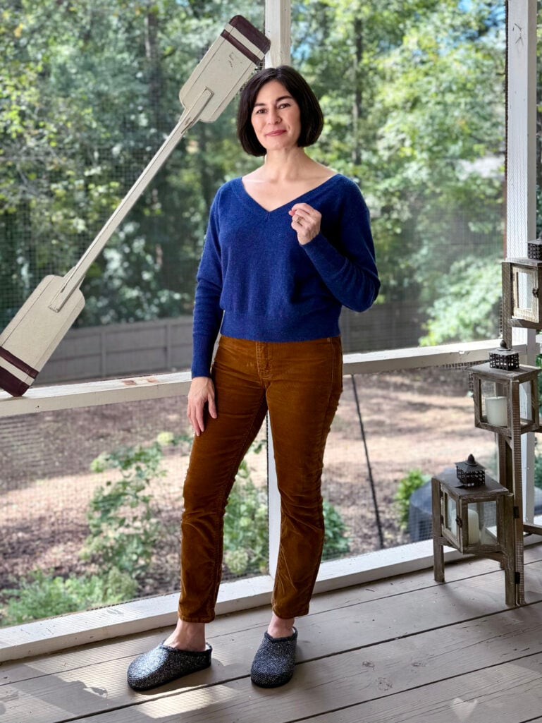 Woman wearing a navy sweater and brown corduroy pants
