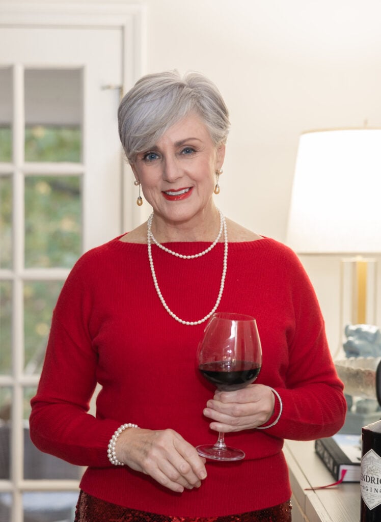 Woman wearing a holiday red sweater and pearls