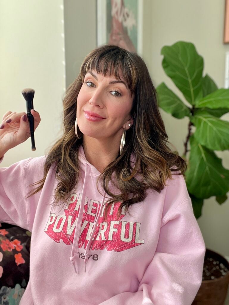 Jennifer holding a complexion brush. 