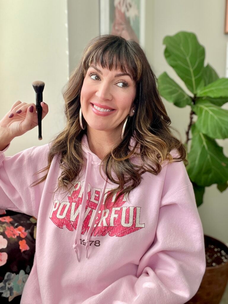 Jennifer holding a complexion brush. 