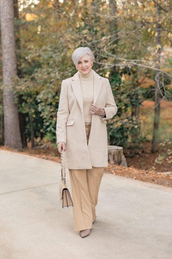 woman over 50 in camel coat and wide-leg pants neutral fall wardrobe essentials