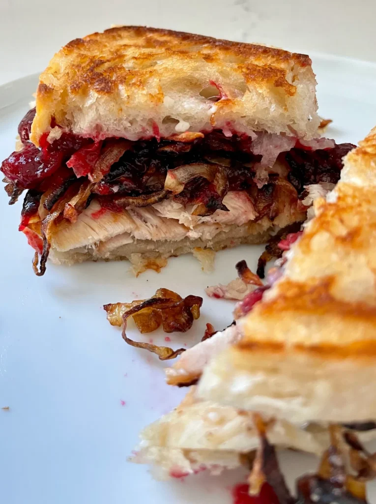 Grilled cheese sandwich with turkey, gruyere, caramelized onions, and cranberry sauce