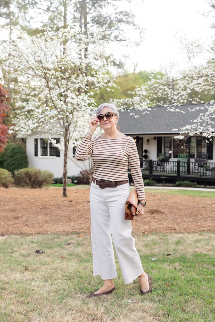 Beth in white wide-leg pants with brown striped boat neck top, brown belt and sunglasses - casual wide leg pants styling for women over 50