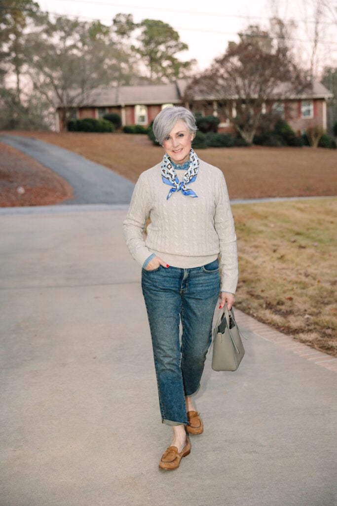 Classic straight leg jeans in medium wash paired with cashmere sweater and leather loafers