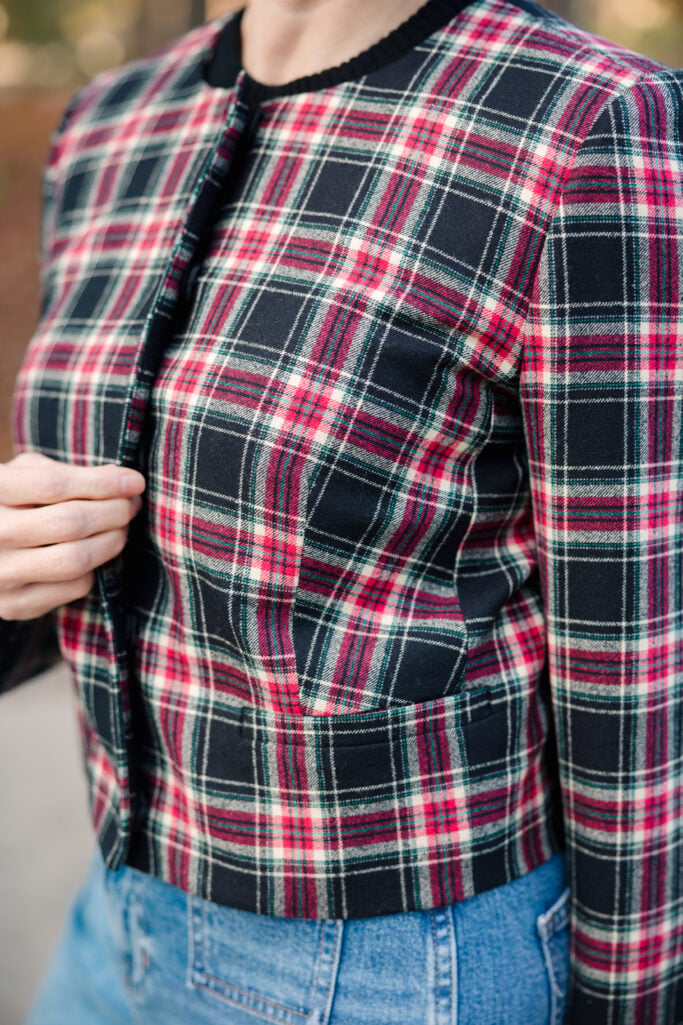 Close-up detail of Stewart tartan plaid jacket fabric showing red, green, white and black holiday pattern 