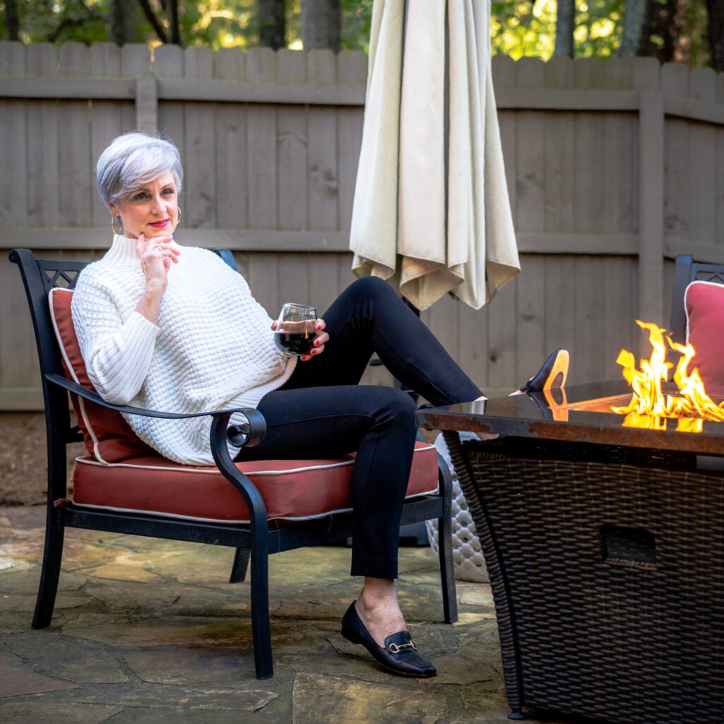 Beth Djalali styling black leggings with an oversized white shirt and ankle boots for women over 50
