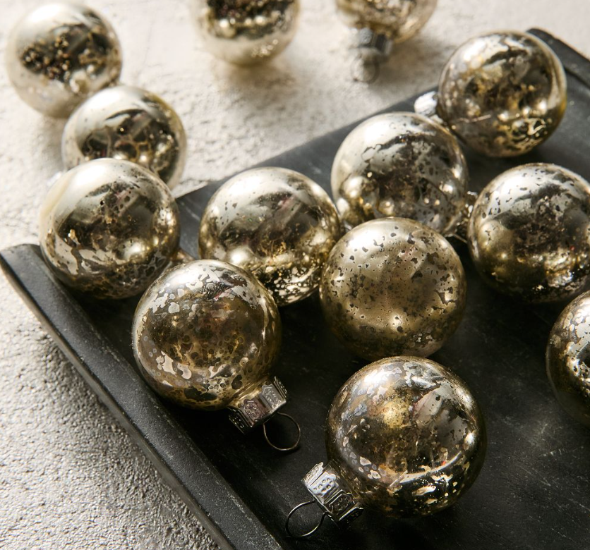 Set of 25 small mercury glass Christmas ornaments with a mottled gold-speckled finish, displayed on a dark tray.
