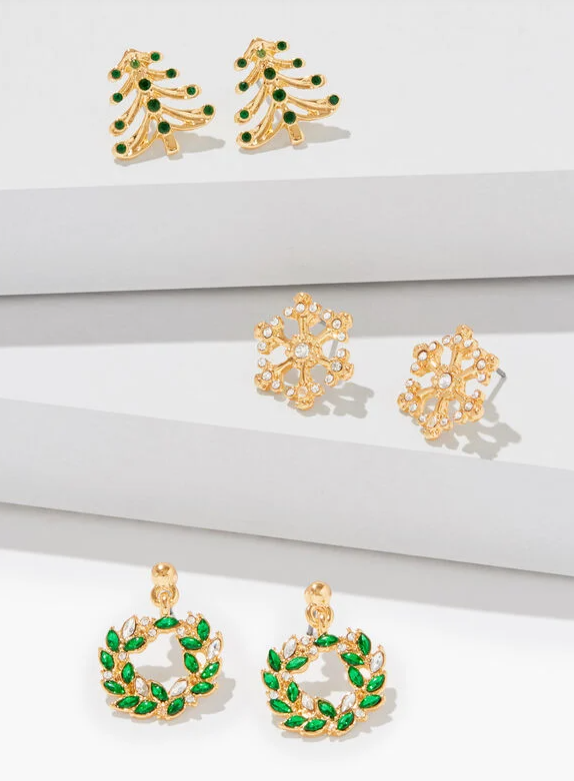 Three pairs of holiday-themed stud earrings - gold Christmas trees with green crystals, crystal snowflakes, and green wreath shapes with clear stones.