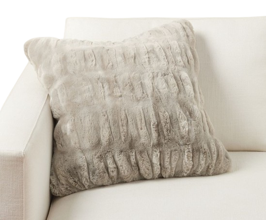 Pottery Barn faux fur ruched pillow cover in a soft neutral taupe tone, styled on a light upholstered sofa for a cozy, textured look.