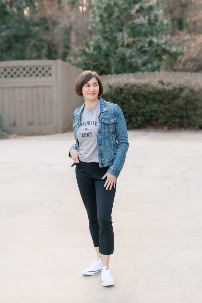 Kelly in full-length petite casual outfit showing denim jacket, Favorite Aunt tee, black ponte kick flare pants and white Converse Chuck 70 sneakers