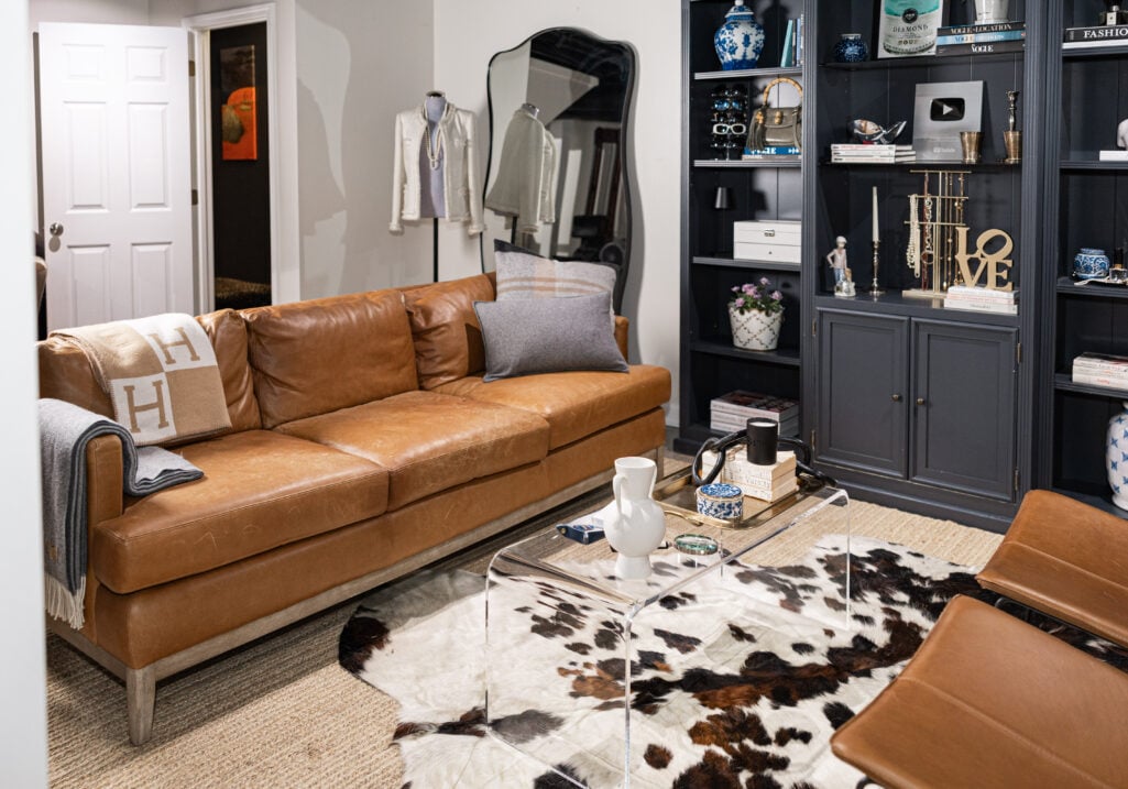 Leather sofa, leather butterfly chairs, Barcelona chairs, and acrylic coffee table on a Grandin Road hand woven jute rug in Beth's basement studio lounge area.
