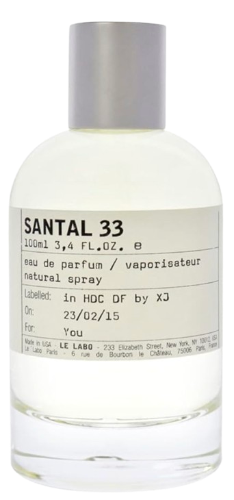 Clear glass bottle of Le Labo Santal 33 eau de parfum with minimalist cream label and gray cap, photographed on a white background.