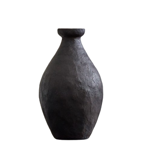 Handcrafted black ceramic vase with an organic shape and matte textured finish, styled on a dark wood surface.