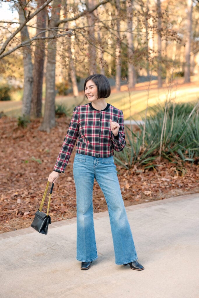 Kelly in a cropped plaid lady jacket with flare jeans and black boots — petite layering done right