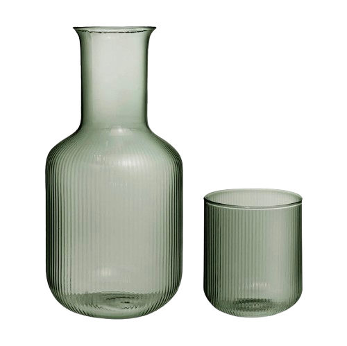 Ribbed glass bedside carafe with matching tumbler in a soft green tint, styled together on a white background as a minimalist bedroom nightstand set.